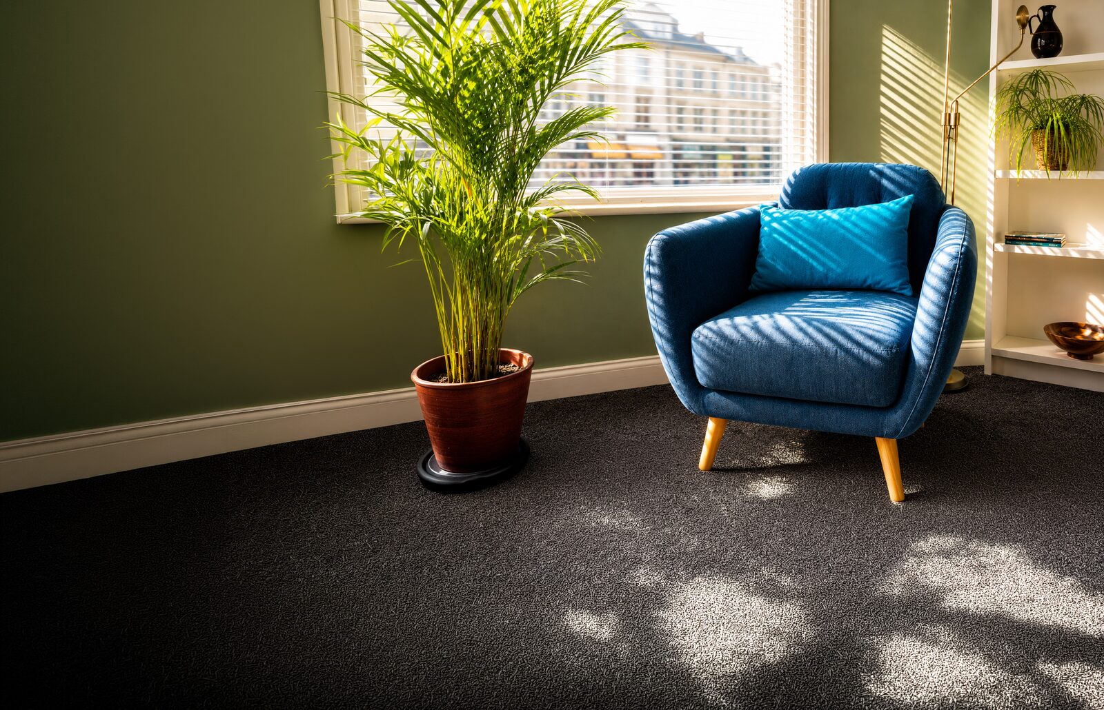 A sunlit green therapy room with a blue armchair and palm