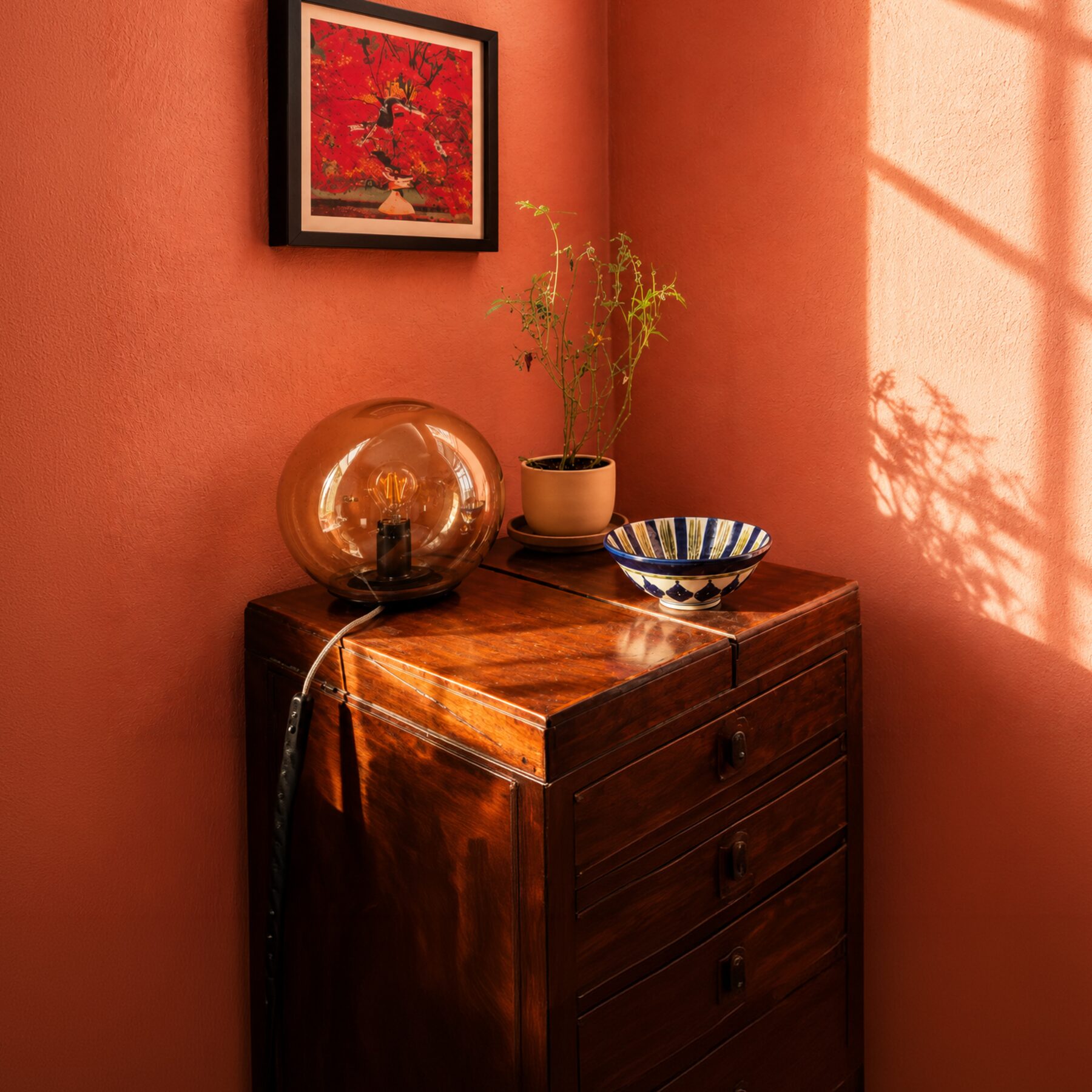 A warmly lit orange therapy room with a wooden cabinet and plants
