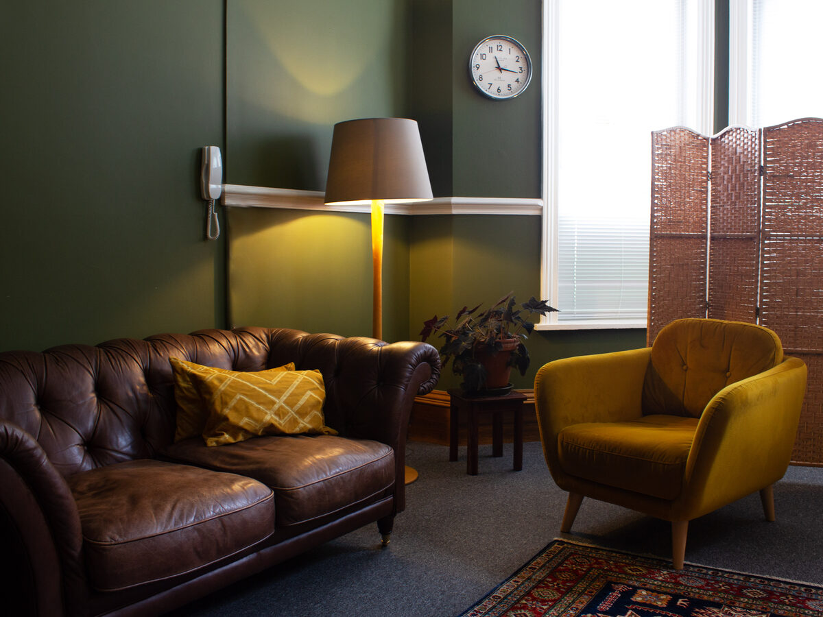 A bright blue therapy room with two armchairs